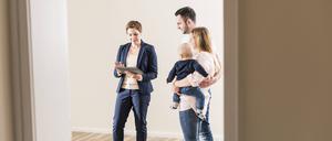 Eine junge Familie bei einer Wohnungsbesichtigung. 