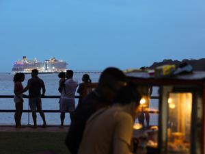 Menschen flanieren am Brasilia Beach in Belém. Im Hintergrund steuert ein Schiff den neuen Hafen der Stadt an.