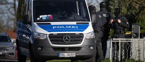 Polizeibeamte stehen bei einer Hausdurchsuchung vor einem Wohnhaus in Reimershagen.