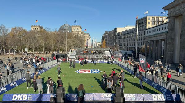 06.11.2025, Berlin: Am Platz vor dem Brandenburger Tor ist Kunstrasen ausgerollt - hier können sich Fans im Flag Football (eine Variante des American Football) ausprobieren. Am 09.11.2025 treffen die Atlanta Falcons beim Berlin Game auf die Indianapolis Colts. Foto: Jordan Raza/dpa +++ dpa-Bildfunk +++