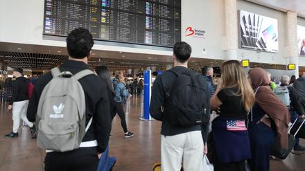 Belgien, Zaventem: Passagiere schauen auf eine Abflugtafel, nachdem mehrere Flüge aufgrund von Drohnenaktivitäten über dem internationalen Flughafen Brüssel-Zaventem in der Nacht auf Mittwoch gestrichen wurden.
