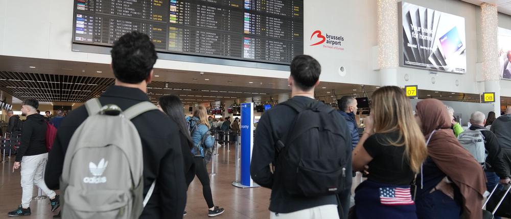 Belgien, Zaventem: Passagiere schauen auf eine Abflugtafel, nachdem mehrere Flüge aufgrund von Drohnenaktivitäten über dem internationalen Flughafen Brüssel-Zaventem in der Nacht auf Mittwoch gestrichen wurden.