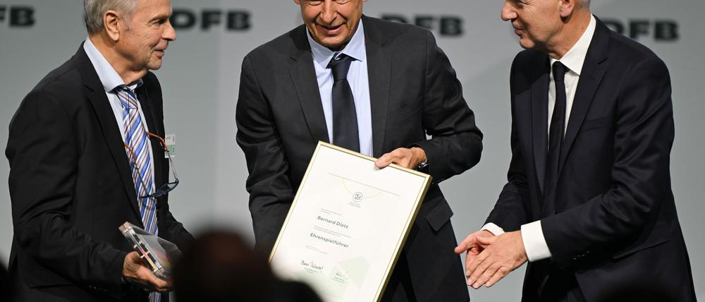 Bernard Dietz (l) wird von Jürgen Klinsmann und DFB-Präsident Bernd Neuendorf für die Ernennung zum Ehrenspielführer gratuliert.