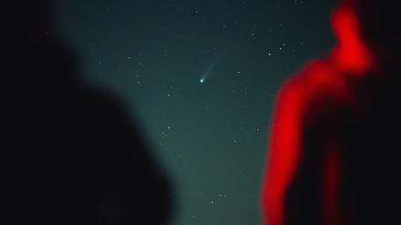 Menschen beobachten einen Komenten am Himmel.