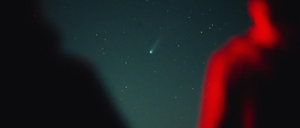 Menschen beobachten einen Komenten am Himmel.