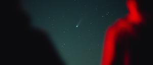 Menschen beobachten einen Komenten am Himmel.