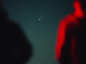 Menschen beobachten einen Komenten am Himmel.