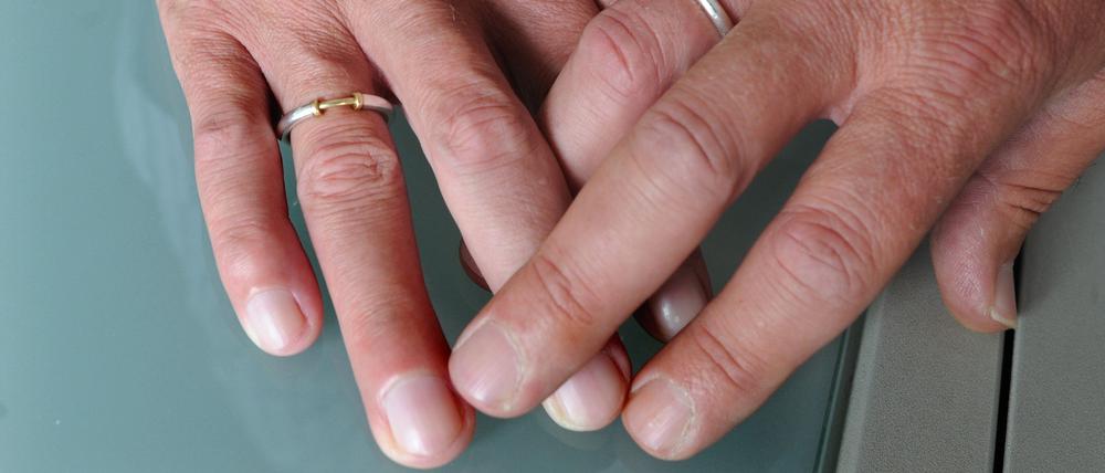 Ein homosexuelles männliches Paar hält die Hände zusammen.