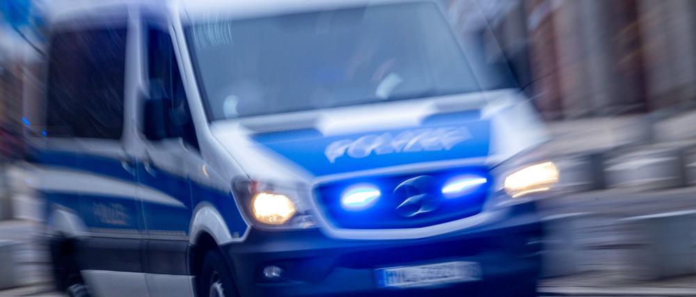 Ein Einsatzfahrzeug der Polizei ist mit Blaulicht und Sirene unterwegs.