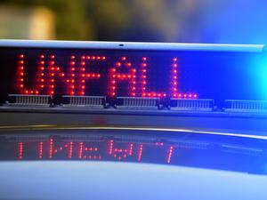 Auf einem Polizeifahrzeug warnt eine Leuchtschrift vor einer Unfallstelle.