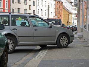 Falschparker in der Stadt: Ein geparktes Auto blockiert einen Bürgersteig.