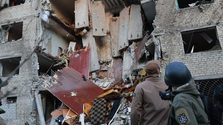30.10.2025, Ukraine, Saporischschja: Nach dem Einschlag einer russischen Rakete in ein Wohnheim arbeiten Rettungskräfte am Schauplatz.