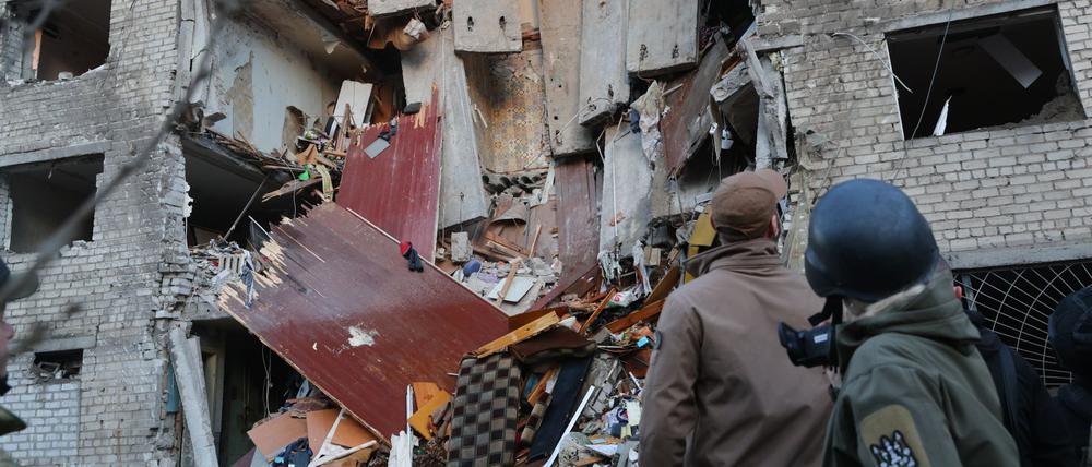 30.10.2025, Ukraine, Saporischschja: Nach dem Einschlag einer russischen Rakete in ein Wohnheim arbeiten Rettungskräfte am Schauplatz.