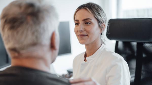 Eine Ärztin im Gespräch mit einem Patienten.