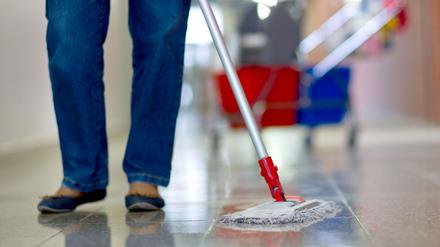 Eine Gebäudereinigerin wischt einen Flur in einer Berufsschule in Schwerin.
