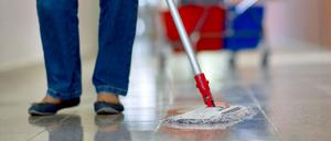 Eine Gebäudereinigerin wischt einen Flur in einer Berufsschule in Schwerin.