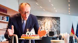 Der deutsche Bundeskanzler Friedrich Merz bläst einige Kerzen auf einer Geburtstagstorte aus, die ihm die Mitarbeiter der Kanzlei anlässlich seines 70. Geburtstags am 11. November 2025 in Berlin überreicht haben.