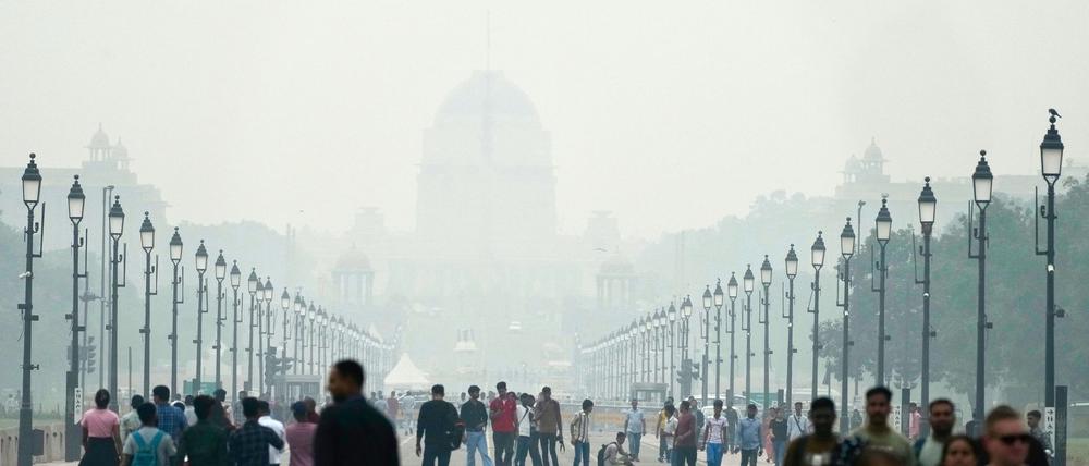 Menschen auf einer in Smog gehüllten Straße in Neu Delhi. (Archivbild)