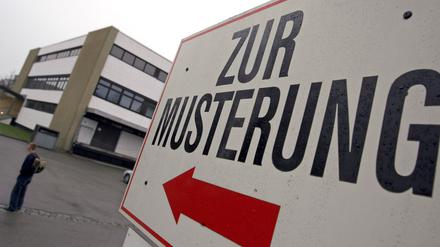 Ein Wehrpflichtiger steht am 04.04.2007 unter einem Hinweisschild mit der Aufschrift „Zur Musterung“ vor dem Kreiswehrersatzamt in Kempten (Symbolbild).