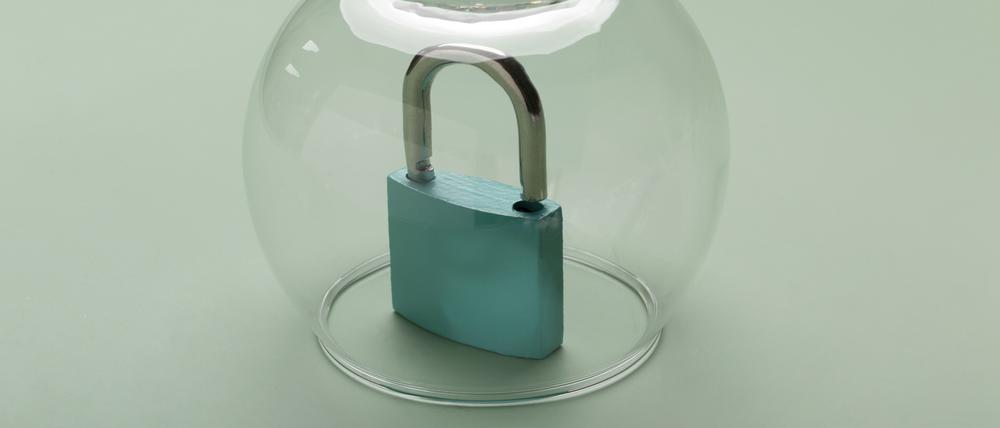 Ein Vorhängeschloss steht unter einer Glaskuppel. 