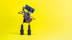 Ein kleiner Roboter spielt Gitarre.