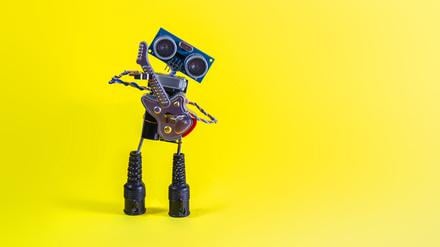 Ein kleiner Roboter spielt Gitarre.