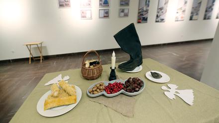 Maiskolben, Kastanien und Eicheln und ein Lederstiefel in der Ausstellung in der Nikolaikirche Potsdam zum Gedenken an den Genozid durch Hunger (Holodomor) in der Ukraine zwischen 1932 und 1933.