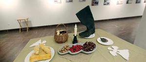 Maiskolben, Kastanien und Eicheln und ein Lederstiefel in der Ausstellung in der Nikolaikirche Potsdam zum Gedenken an den Genozid durch Hunger (Holodomor) in der Ukraine zwischen 1932 und 1933.