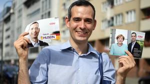 Timur Husein hält am 30.08.2017 in Berlin beim Haustürwahlkampf Flyer seiner Partei.