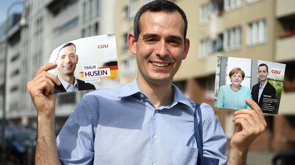 Timur Husein hält am 30.08.2017 in Berlin beim Haustürwahlkampf Flyer seiner Partei.