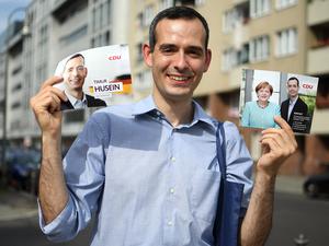 Timur Husein hält am 30.08.2017 in Berlin beim Haustürwahlkampf Flyer seiner Partei.
