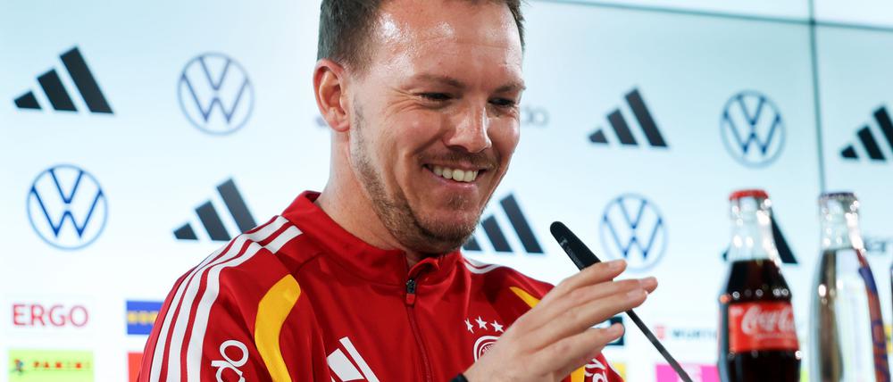 Julian Nagelsmann richtet das Mikrofon bei der Pressekonferenz.