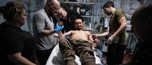 11.11.2025, Ukraine, Gebiet Donezk: Auf diesem Foto leisten Sanitäter dem verwundeten Soldaten Oleg Solontschak an einem Stabilisierungspunkt in der Nähe von Kostjantyniwka in der Region Donezk erste Hilfe.