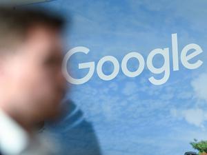 Ein Mann steht vor dem Google Logo bei der Vorstellung des Google Investitionsplans für Deutschland. 