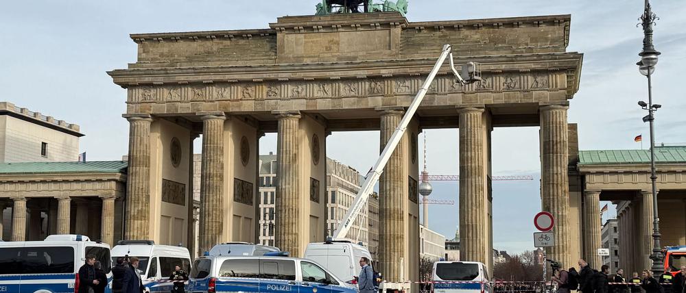 Die Polizei klettert auf das Brandenburger Tor in Berlin, um Demonstranten festzunehmen. 