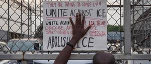 Protestors Rally Outside Delaney Hall ICE Detention Facility In Newark, NJ - 13th Jun 2025 A protestor holds up a sign, reading Unite Against I.C.E , against the gate of Delaney Hall Detention Facility during a demonstration. Demonstrators gathered outside of the facility, where four detainees escaped after allegedly breaking through a wall, to voice opposition to increased raids against migrants. Newark United States Copyright: xDerekxFrenchx/xSOPAxImagesx NJ_DelaneyHall13JUN25_0003