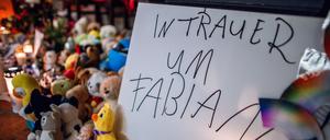 Kerzen, Plüschtiere und ein Schild „In Trauer um Fabian“ stehen vor einer Kirche in Güstrow.