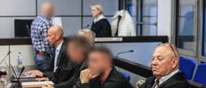 Die drei Angeklagten (hinten l, 2.v.r. und 3.v.r) sitzen zwischen ihren Anwälten Sven Schnitzer (2.v.l.) und Hartmut Moizio (r) im Landgericht Wuppertal.