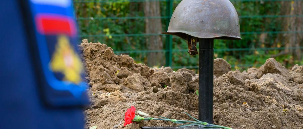 Ein Stahlhelm eines im Zweiten Weltkrieg gefallenen sowjetischen Soldaten schmückt ein Grab. 