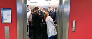 Bei einem Besuch der Uniklinik Gießen drängen sich Bundesgesundheitsminister Jens Spahn (CDU, l), und Hessens Ministerpräsident Volker Bouffier (CDU, M) mit Begleitern in einem Fahrstuhl.