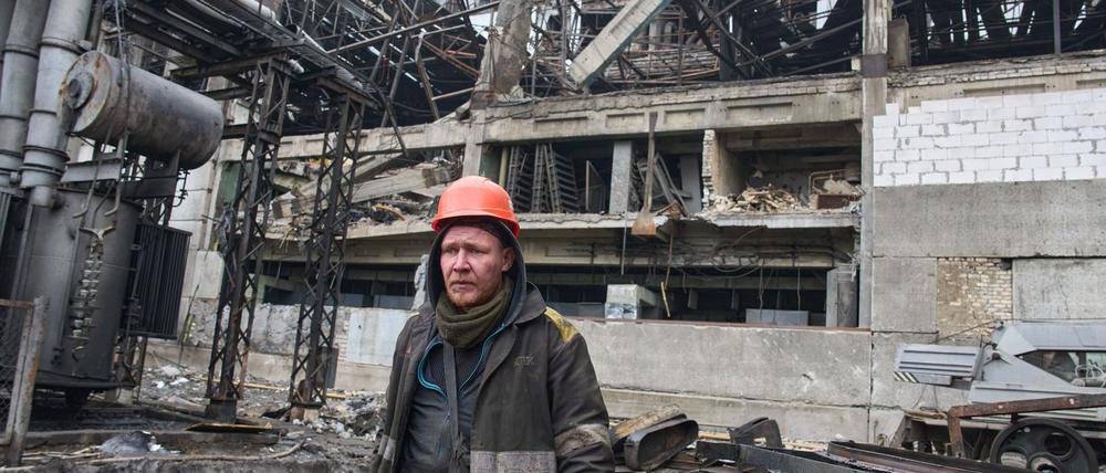 13.11.2025, Ukraine, --: Ein Arbeiter geht an einem beschädigten Kraftwerk vorbei, das nach den jüngsten russischen Raketen- und Drohnenangriffen an einem ungenannten Ort in der Ukraine steht. Foto: Efrem Lukatsky/AP/dpa +++ dpa-Bildfunk +++