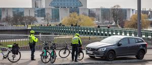 Polizisten der Fahrradstaffel stellen Strafzettel für einen Falschparker auf der Hugo-Preuß-Brücke nahe dem Bundeskanzleramt aus.