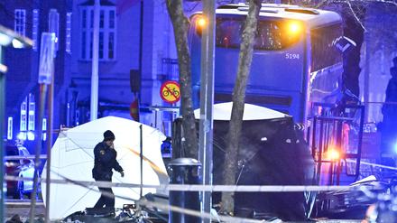 Polizisten sind in der Nähe des Busses an der Unfallstelle in Stockholm zu sehen.