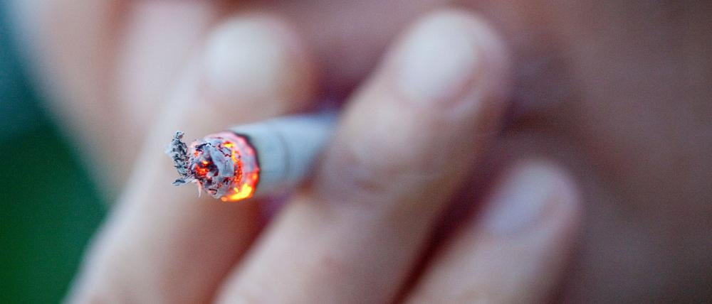 Eine Person zieht an einer Zigarette.