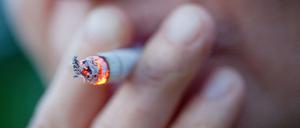 Eine Person zieht an einer Zigarette.