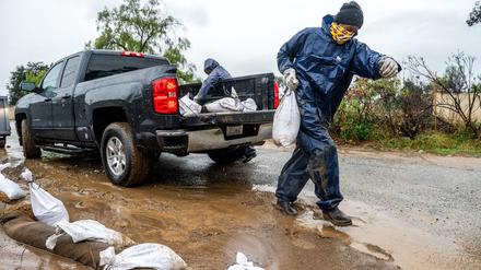 Bewohner versuchen in Kalifornien, ihre Grundstücke mit Sandsäcken vor den Wassermassen zu schützen.