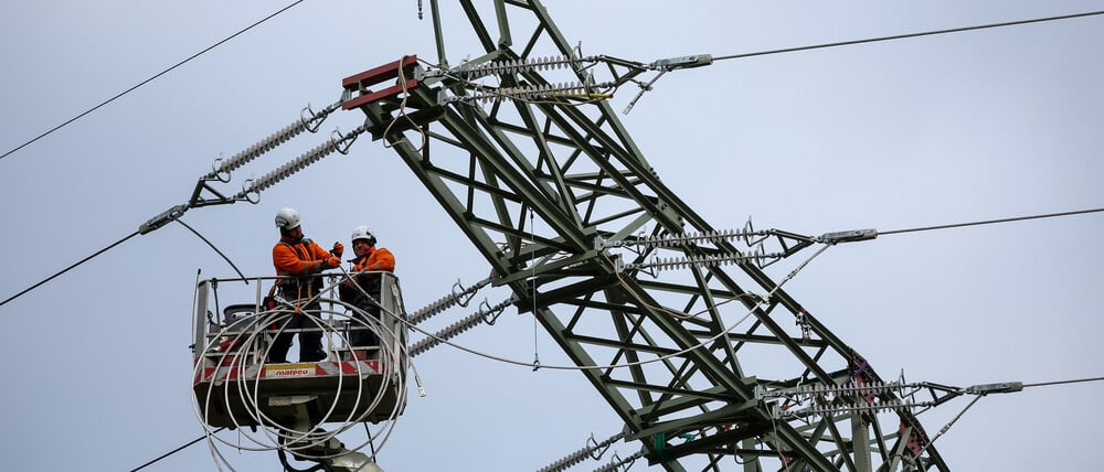 Monteure erneuern eine Hochspannungsleitung.