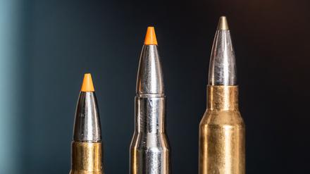 Jagdpatronen im Kaliber 308 Winchester (l-r), 30-06 Springfield und 300 Winchester Magnum stehen bei einem Jäger auf einem Waffenschrank. (Symbolbild)