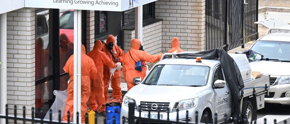 In Schutzanzügen wurden die Schulen gesäubert und der Sand entsorgt.