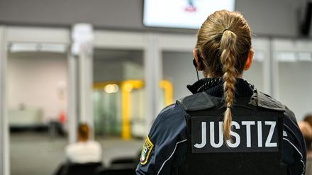 Eine Justizbeamtin steht vor dem Verhandlungssaal im temporären Gerichtsgebäude des Landgerichtes Magdeburg, wo der Prozess gegen den Attentäter vom Magdeburger Weihnachtsmarkt verhandelt wird.